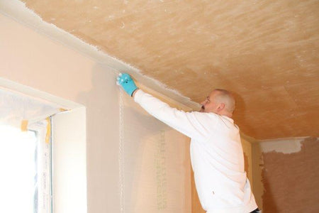 Handwerker bringt Armierung auf die UdiIN 2CM Dämmplatten auf