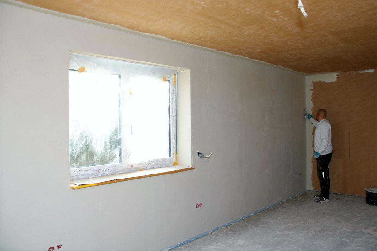 Handwerker verputzt eine mit UdiIN 2CM gedämmte Wand